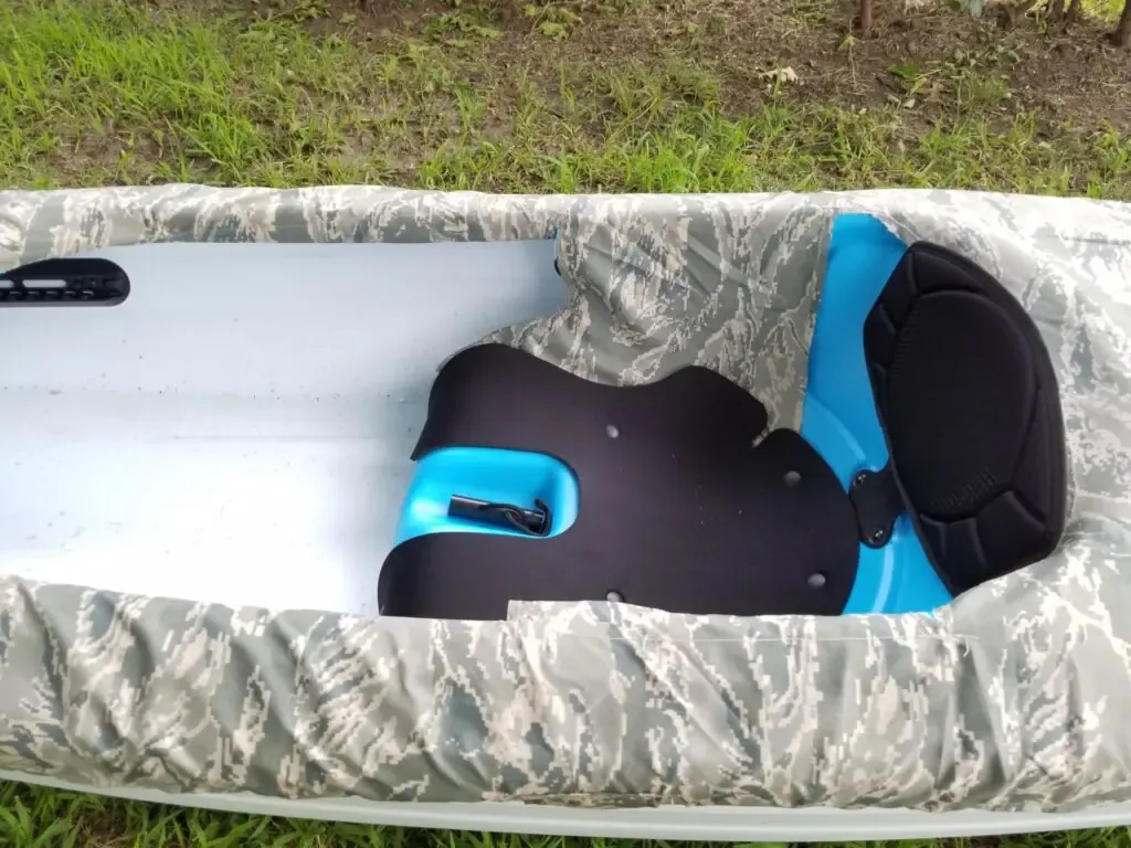 Homemade camo cover cut and tucked into the seat of a kayak
